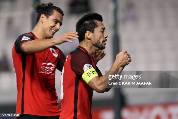 Al-Rayyan SC's Qatari-Uruguayan forward Sebastian Soria congratulates his Qatari-Brazilian midfielder and captain Rodrigo Tabata, after the latter...