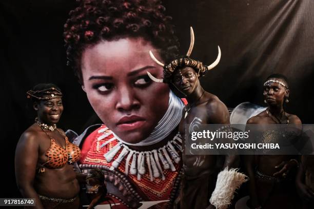 Dancers from Kenya's Luo tribe pose in front of an image of Kenyan actress Lupita Nyong'o before the African premier of the Marvel film "Black...