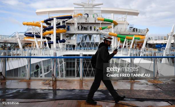 Worker walks across the upper deck of US shipowner Royal Caribbeans new Oasis-class cruise ship, Symphony of the Seas, the largest passenger ship...