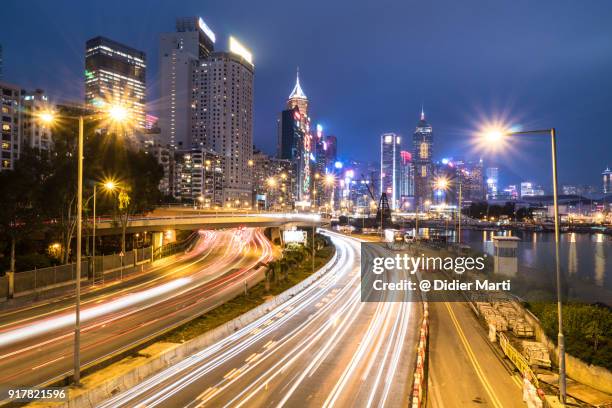 traffic rushing toward causeway bay in hong kong island at night - causeway bay stock pictures, royalty-free photos & images