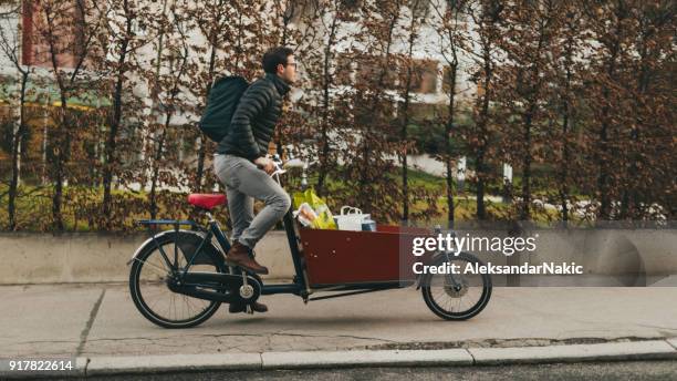 delivery boy on a cargo bike - cargo bike stock pictures, royalty-free photos & images