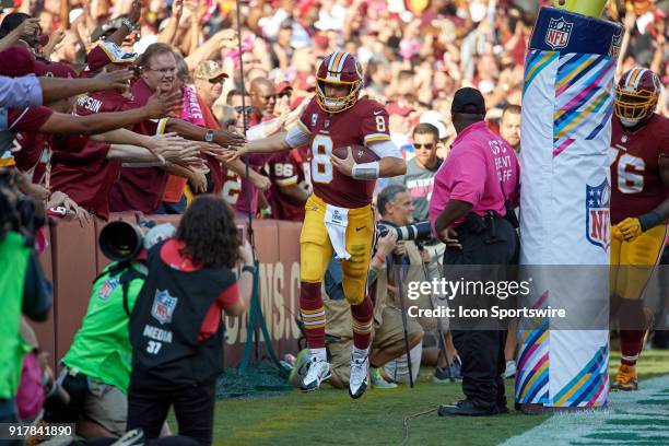 Washington Redskins quarterback Kirk Cousins celebrates with fans after scoring a touchdown during a NFL football game between the San Francisco...