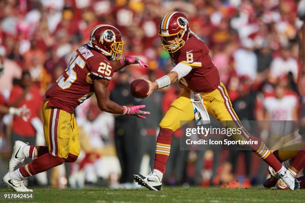 Washington Redskins quarterback Kirk Cousins hands the football to Washington Redskins running back Chris Thompson during a NFL football game between...