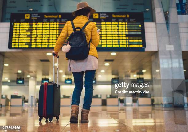 tourist at barcelona airport checking the arrival departure board - travel cancellation stock pictures, royalty-free photos & images