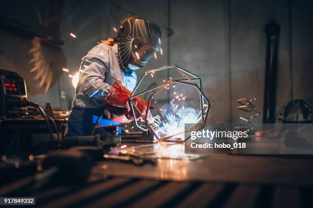 woman using a welding machine - welding stock pictures, royalty-free photos & images