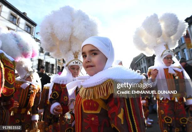 Boy dressed as a "Gilles", the oldest and principal participants in the Carnival of Binche in Belgium, wearing their white feather hat, takes part in...