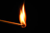 Fire burning on matchstick. Isolated on black background