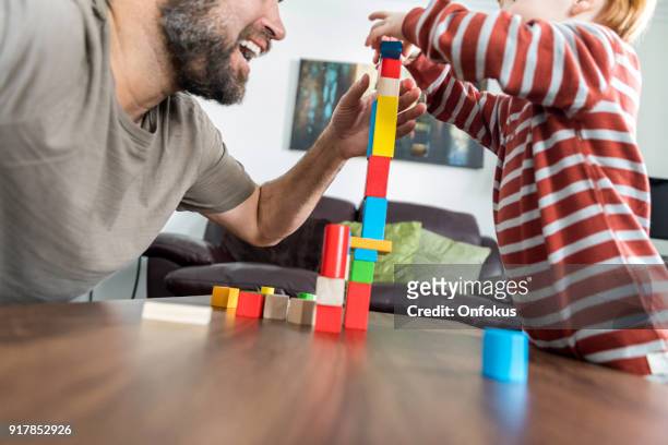 père et bébé garçon jouant avec des cubes colorés - bébé jeu photos et images de collection