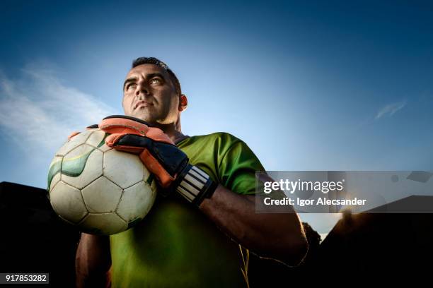 segurando uma bola de futebol que atua como goleiro - goalkeeper - fotografias e filmes do acervo