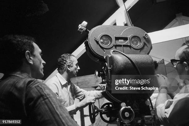 Italian film director Michelangelo Antonioni , along with unidentified crew members, stands behind the camera on the set of his film 'Blow-Up,'...