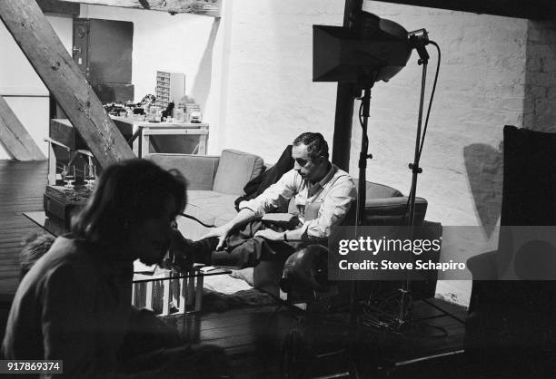 View of Italian film director Michelangelo Antonioni on the set of his film. 'Blow-Up,' London, England, 1965. The woman at fore is unidentified.