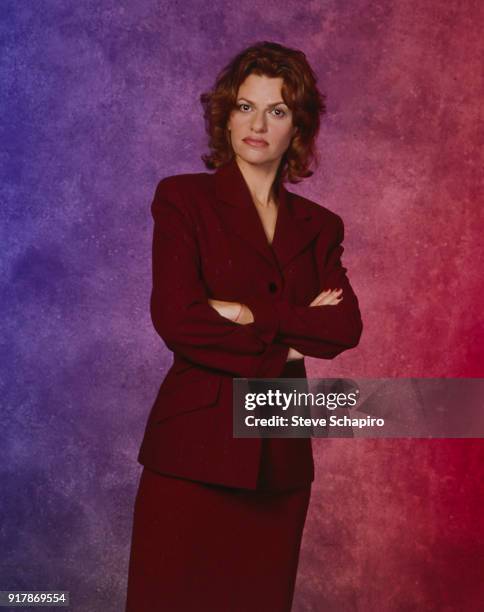 Portrait of American actress, comedienne, and musician Sandra Bernhard, in a red suit, as she poses with her arms crossed, Los Angeles, California,...