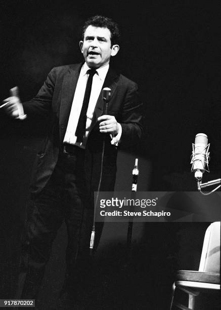 Cigarette in his hand, American author Norman Mailer speaks onstage at Carnegie Hall, New York, New York, May 31, 1963.