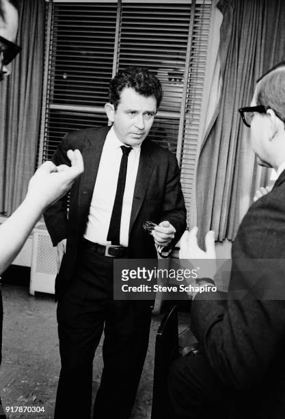 Backstage at Carnegie Hall, American author Norman Mailer speaks with unidentified others, New York, New York, May 31, 1963.