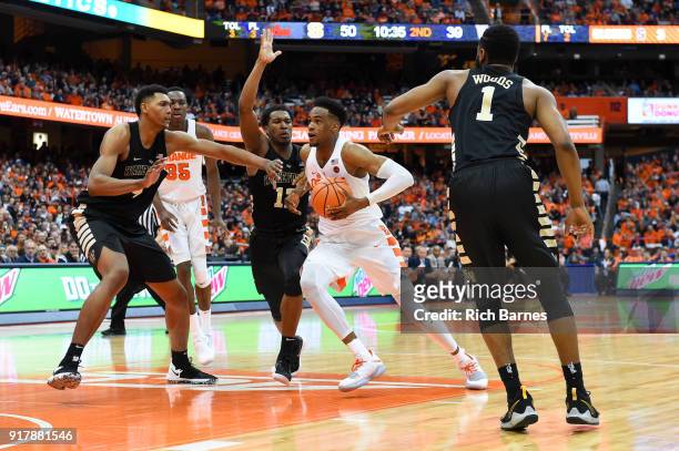 Oshae Brissett of the Syracuse Orange drives to the basket between the defense of Bryant Crawford, Doral Moore and Keyshawn Woods of the Wake Forest...
