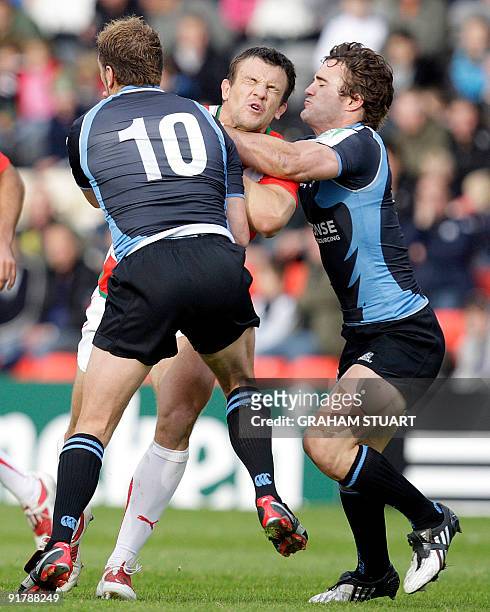 Glasgow Warriors' Dan Parks and Thom Evans tackle Biarritz's Damien Traille during their European Cup, pool 2, round one, rugby union match at...