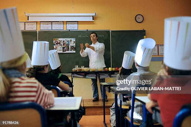 Head chef of the restaurant La Grenouillère, Alexandre Gauthier explains difference in tastes of various types of apple to primary school children...