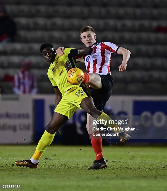 Lincoln City's Scott Wharton vies for possession with Cheltenham Town's Elijah Adebayo during the Sky Bet League Two match between Lincoln City and...