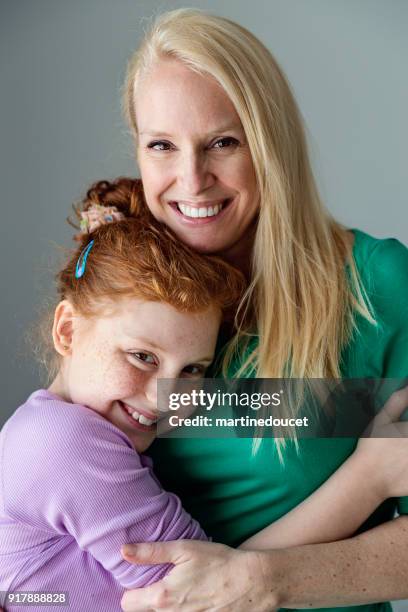 blonde mother and expressive preteen redhead daughter portrait. - ginger bush stock pictures, royalty-free photos & images