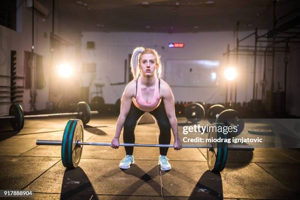 donna forte che fa esercitazione dead-lift - sollevamento pesi femminile foto e immagini stock