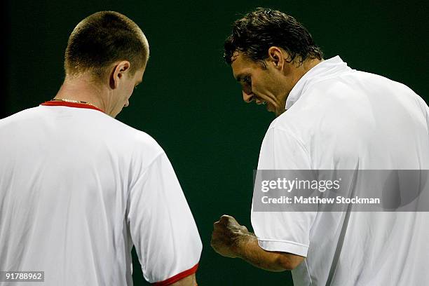 Michal Mertinak of Slovakia and Frantisek Cermak of the Czech Republic confer between points while Robert Lindstedt of Sweden is playing during day...