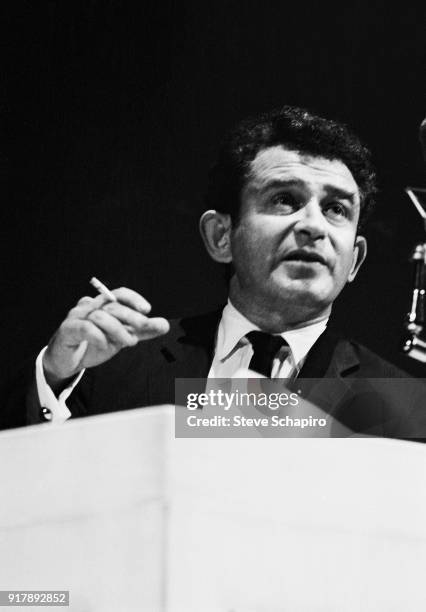 Cigarette in his hand, American author Norman Mailer speaks onstage at Carnegie Hall, New York, New York, May 31, 1963.