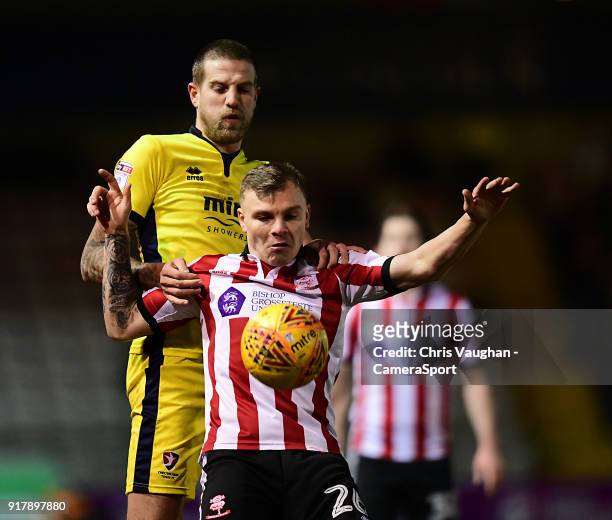 Lincoln City's Harry Anderson shields the ball from Cheltenham Town's Harry Pell during the Sky Bet League Two match between Lincoln City and...