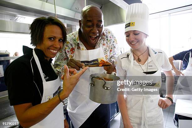 Young athlete Jess Burns in the kitchen with Dame Kelly Holmes and Ainsley Harriott during the Aviva On Camp with Kelly Cookery Get-Together on...