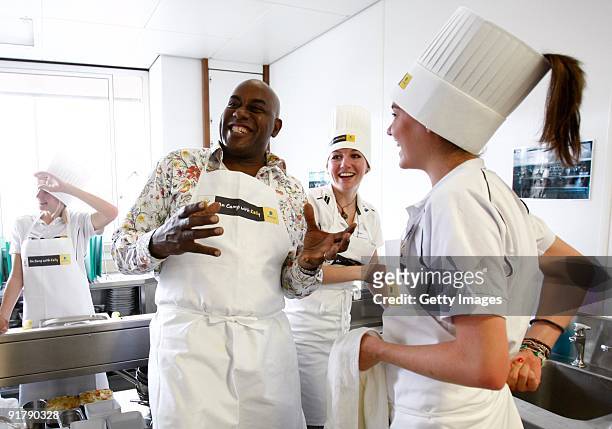 Chef Ainsley Harriott shares a joke with young athletes Jess Burns and Kate Avery in the kitchen during the Aviva On Camp with Kelly Cookery...