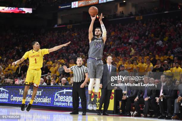 Aaron Falzon of the Northwestern Wildcats takes a jump over Anthony Cowan Jr. #1 of the Maryland Terrapins during a college basketball game at the...