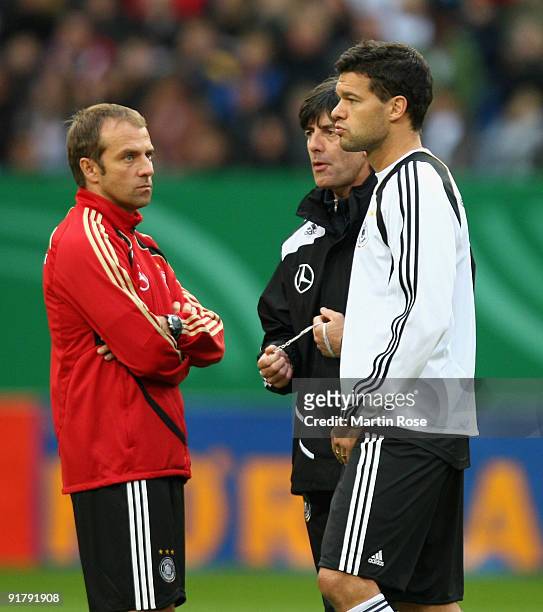 Michael Ballack talks to head coach Joachim Loew and assistant coach Hansi Flick during the German National team training session at the Hamburg...