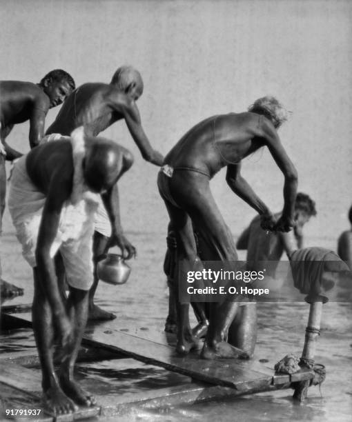 Men making their ablutions at the Bathing Ghats on the River Ganges in Benares , Uttar Pradesh, India, 1929.