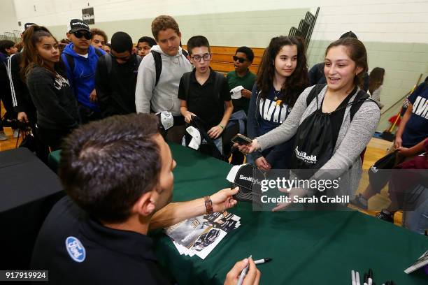 Aric Almirola, driver of the Smithfield Ford Fusion for Stewart-Haas Racing in the Monster Energy NASCAR Cup Series, signs autographs for honor-roll...