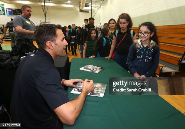 Aric Almirola, driver of the Smithfield Ford Fusion for Stewart-Haas Racing in the Monster Energy NASCAR Cup Series, signs autographs for honor-roll...