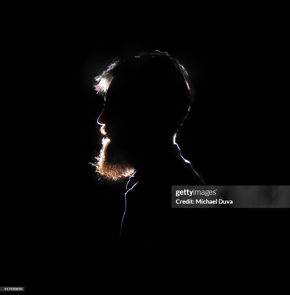 Silhouette of bearded man smiling