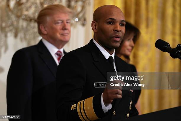 Surgeon General Jerome Adams speaks as President Donald Trump and first lady Melania Trump look on during a reception in the East Room of the White...