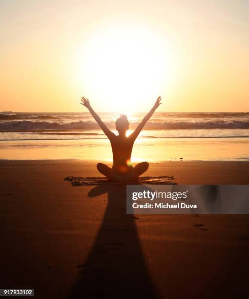 sunset arms raised yoga pose - spirituelle erleuchtung stock-fotos und bilder