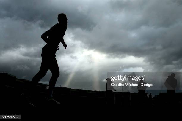 Hawks players walk out as a storm whips through in the background during a Hawthorn Hawks AFL training session on February 14, 2018 in Melbourne,...