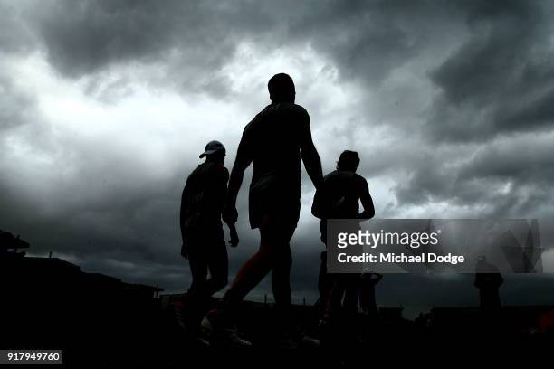 Tom Mitchell of the Hawks walks out as a storm whips through in the background during a Hawthorn Hawks AFL training session on February 14, 2018 in...
