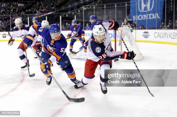 Casey Cizikas of the New York Islanders and Oliver Bjorkstrand of the Columbus Blue Jackets chase after the puck in the first period during their...