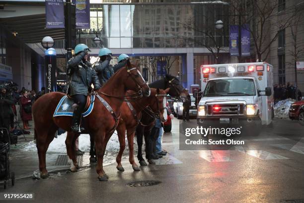 Chicago police officers salute as an ambulance carrying the remains of Cmdr. Paul Bauer leaves Northwestern Memorial Hospital on February 13, 2018 in...