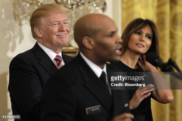 President Donald Trump, left, and First Lady Melania Trump, right, smile as Vice Admiral Jerome Adams, the U.S. Surgeon General, speaks during a...