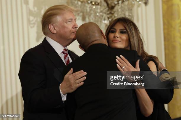 President Donald Trump, left, and First Lady Melania Trump, right, greet Vice Admiral Jerome Adams, the U.S. Surgeon General, during a National...