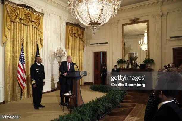 President Donald Trump, second left, speaks as Vice Admiral Jerome Adams, the U.S. Surgeon General, left, listens during a National African American...