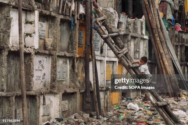 Child seen at the slum in the cemetery. In the center of Pasay District of Metro Manila is a cemetery where over 10,000 deceased people is resting in...