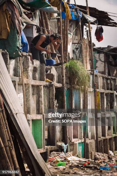 Man seen washing his face at the graveyard. In the center of Pasay District of Metro Manila is a cemetery where over 10,000 deceased people is...