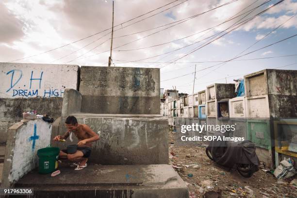 Local man seen brushing his teeth on a gravestone. In the center of Pasay District of Metro Manila is a cemetery where over 10,000 deceased people is...