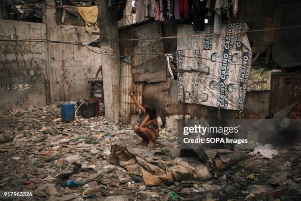 Young girl seen in a slum near a cemetery. In the center of Pasay District of Metro Manila is a cemetery where over 10,000 deceased people is resting...