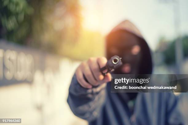 young man took aim with pistol near village roads. - assassino imagens e fotografias de stock