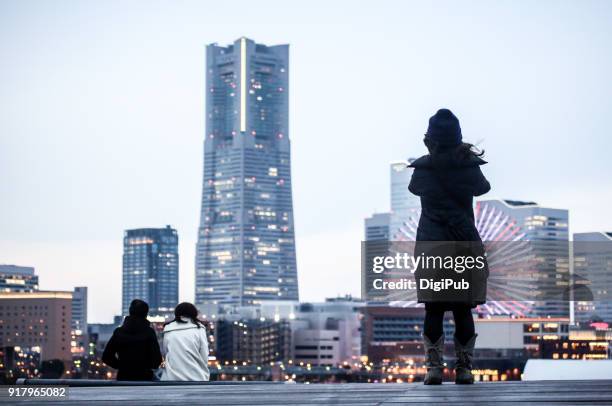 sightseers watching yokohama minatomirai on the roof of onsanbashi - minato mirai stockfoto's en -beelden